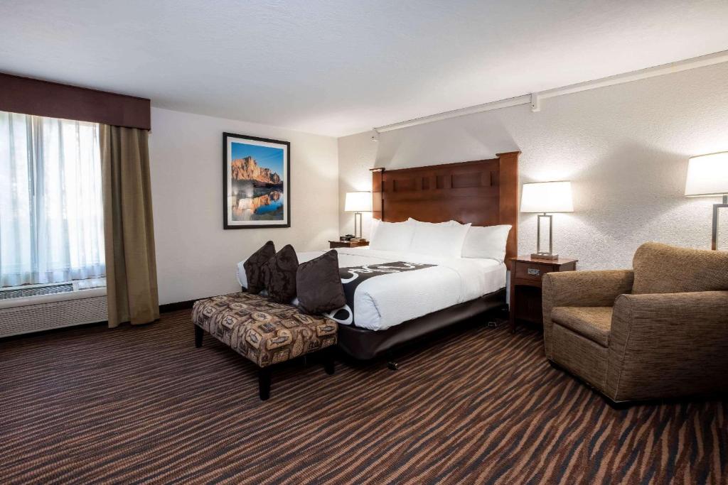 a hotel room with a bed and a chair at La Quinta Inn by Wyndham Bend in Bend