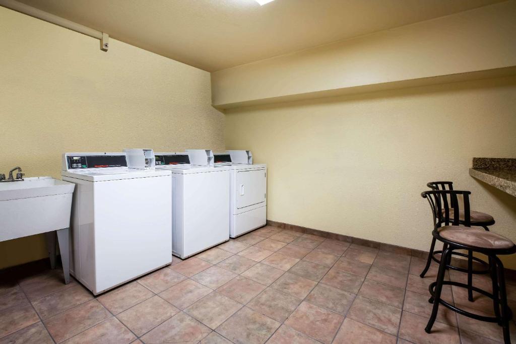 a laundry room with white washers and a counter and chairs at La Quinta Inn by Wyndham Bend in Bend