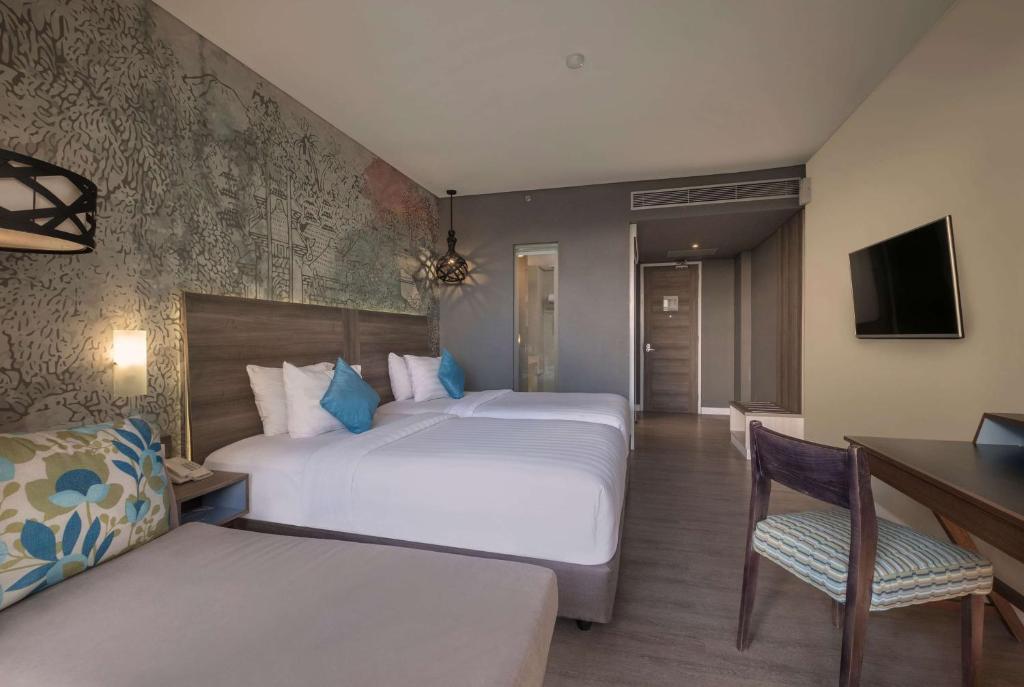 Un pat sau paturi într-o cameră la Wyndham Garden Kuta Beach Bali