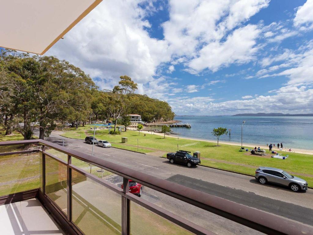 a balcony with a view of a road and the water at Collendina 4 fantastic water views and sea breezes in Nelson Bay