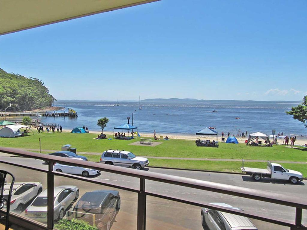 een uitzicht op een strand met auto's op een weg bij Collendina 3 position and water views in Nelson Bay
