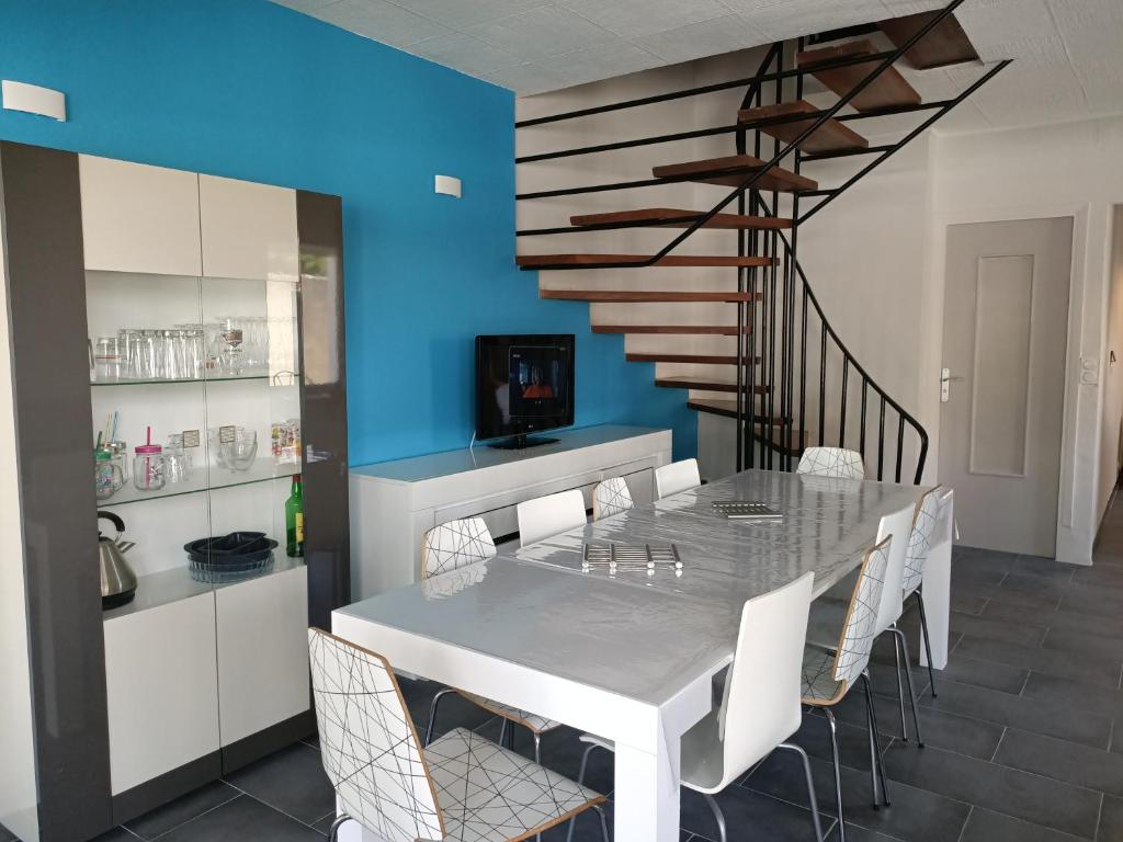 uma sala de jantar com uma mesa branca e cadeiras em Location Bord de mer, villa de vacances 9 personnes - jardin em Valras-Plage