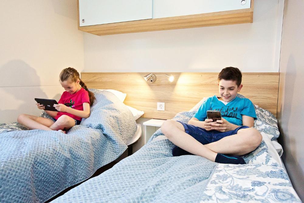 Łóżko lub łóżka w pokoju w obiekcie Hungarospa Thermal Camping Mobilház