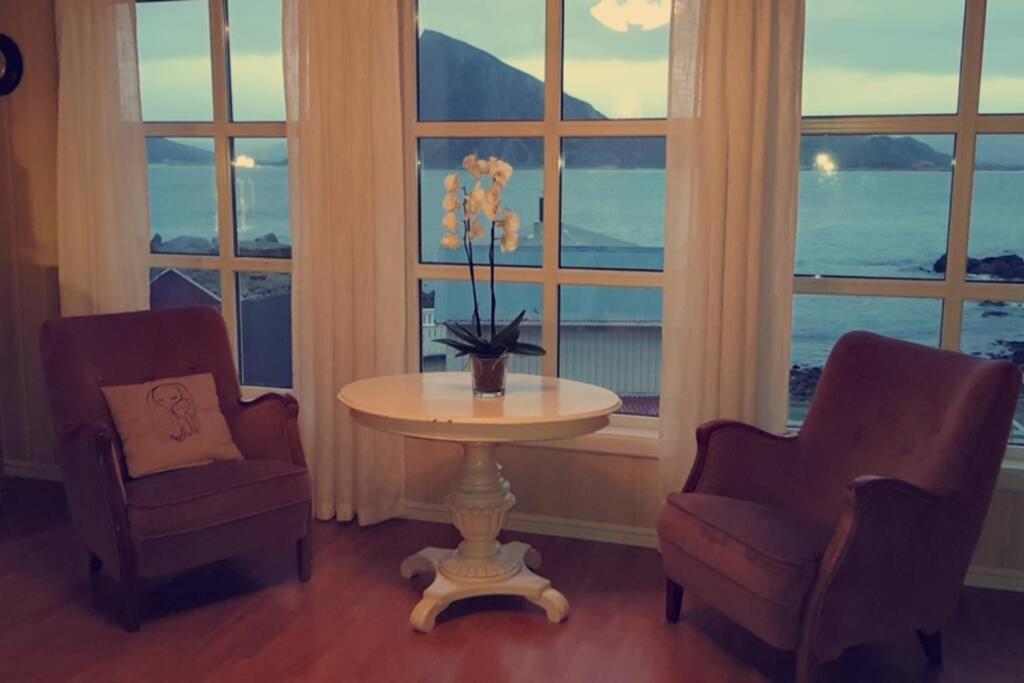 two chairs and a table in a room with windows at Lofoten- Enjoy the Nature-With a beautiful beach in Napp