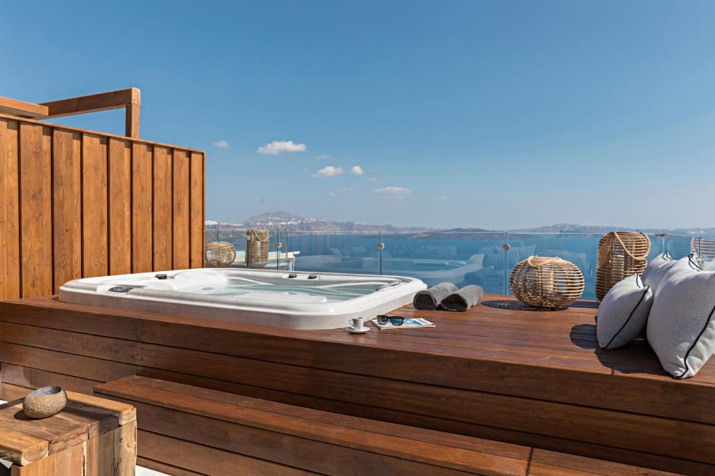 a bath tub sitting on top of a wooden deck at 3 Elements by Stylish Stays in Oia