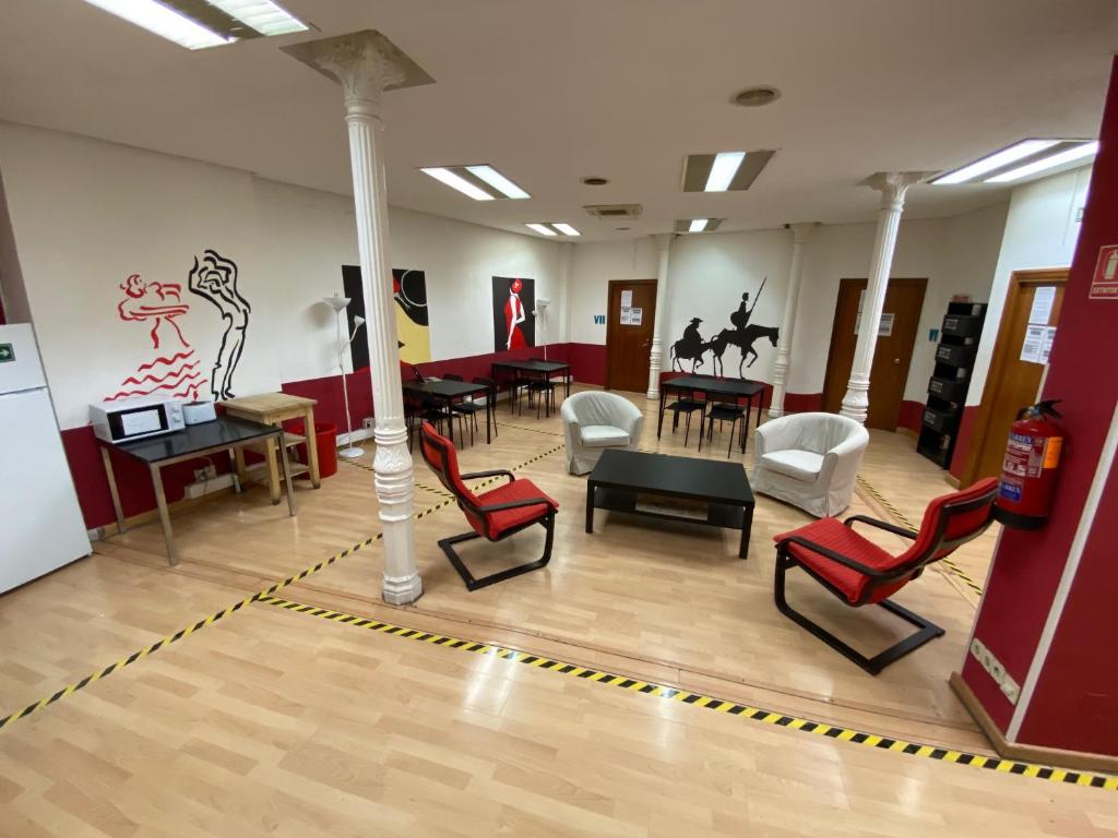 Zimmer mit Stühlen, Tischen und einer Stange in der Unterkunft Bed Madrid in Madrid