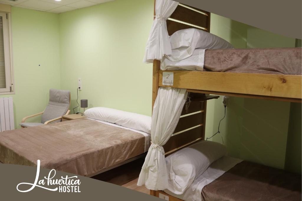two bunk beds in a room with a bed at Hostel La Huertica in Valtierra