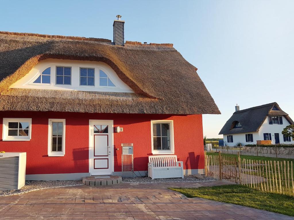 a red house with a thatched roof at Haus Elve in Zierow