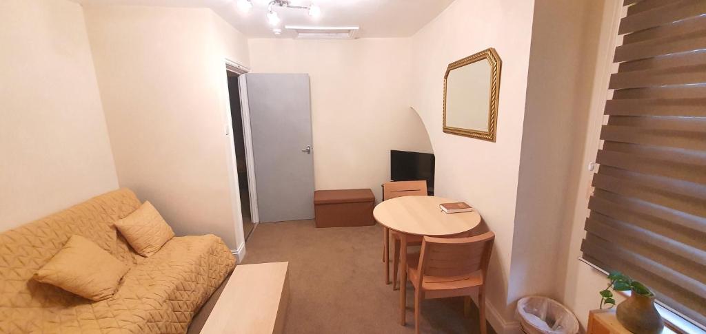 una pequeña sala de estar con sofá y mesa. en Grace Apartments - Living Waters 1, en Ashford
