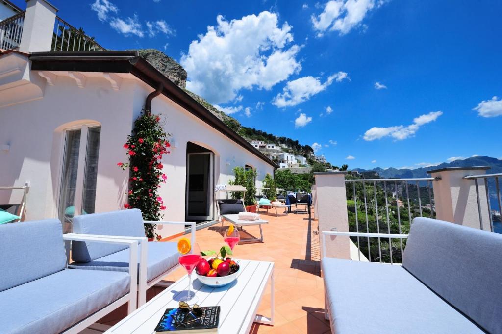 un balcón con muebles blancos y un árbol de Navidad en Amalfi Blu Retreat, en Amalfi