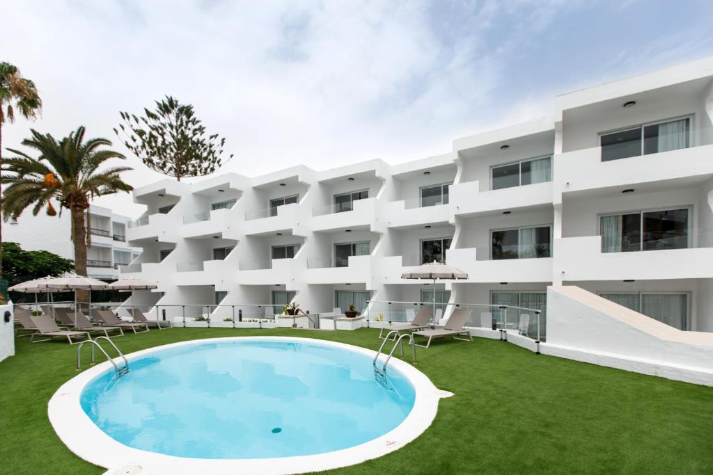 an exterior view of a hotel with a large swimming pool at Alsol Guatiza in Playa del Ingles