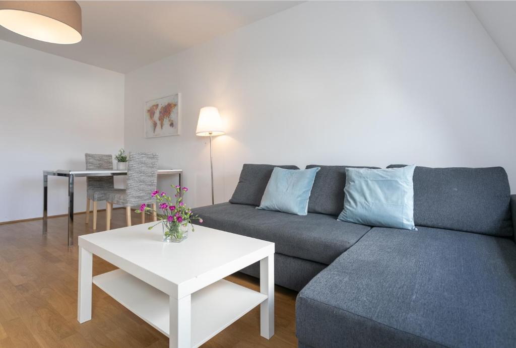 ein Wohnzimmer mit einem Sofa und einem Tisch in der Unterkunft Between Schoenbrunn and City Center Apt 35 in Wien