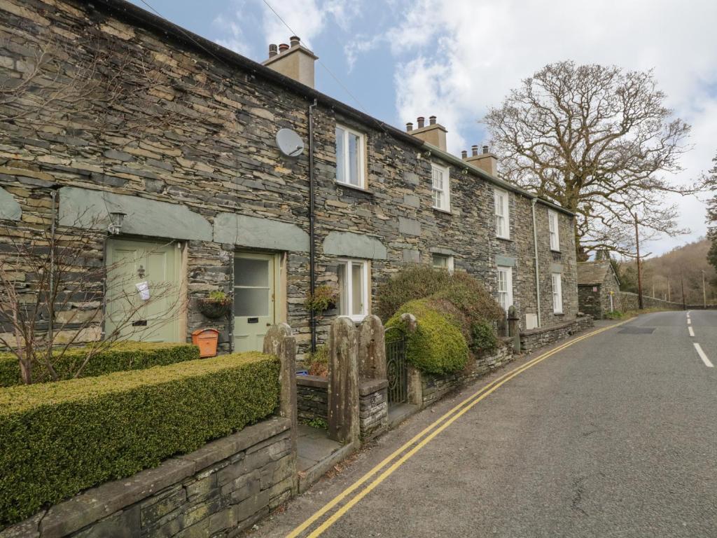 a row of stone houses on the side of a road at Oak Tree Cottage in Coniston