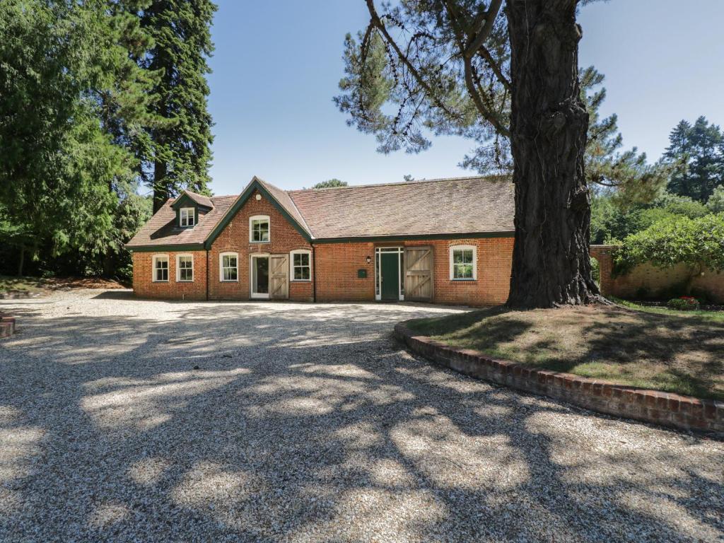 a brick house with a tree in the driveway at The Coach House in Fordingbridge