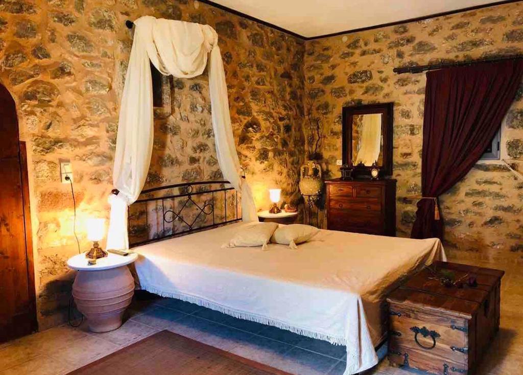 sypialnia z dużym łóżkiem i oknem w obiekcie Kamares Stone House 5 w mieście Álika
