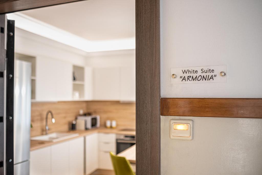 een deur met een bord met witte glimlach kanatown bij White Suite Armonia in Thessaloniki