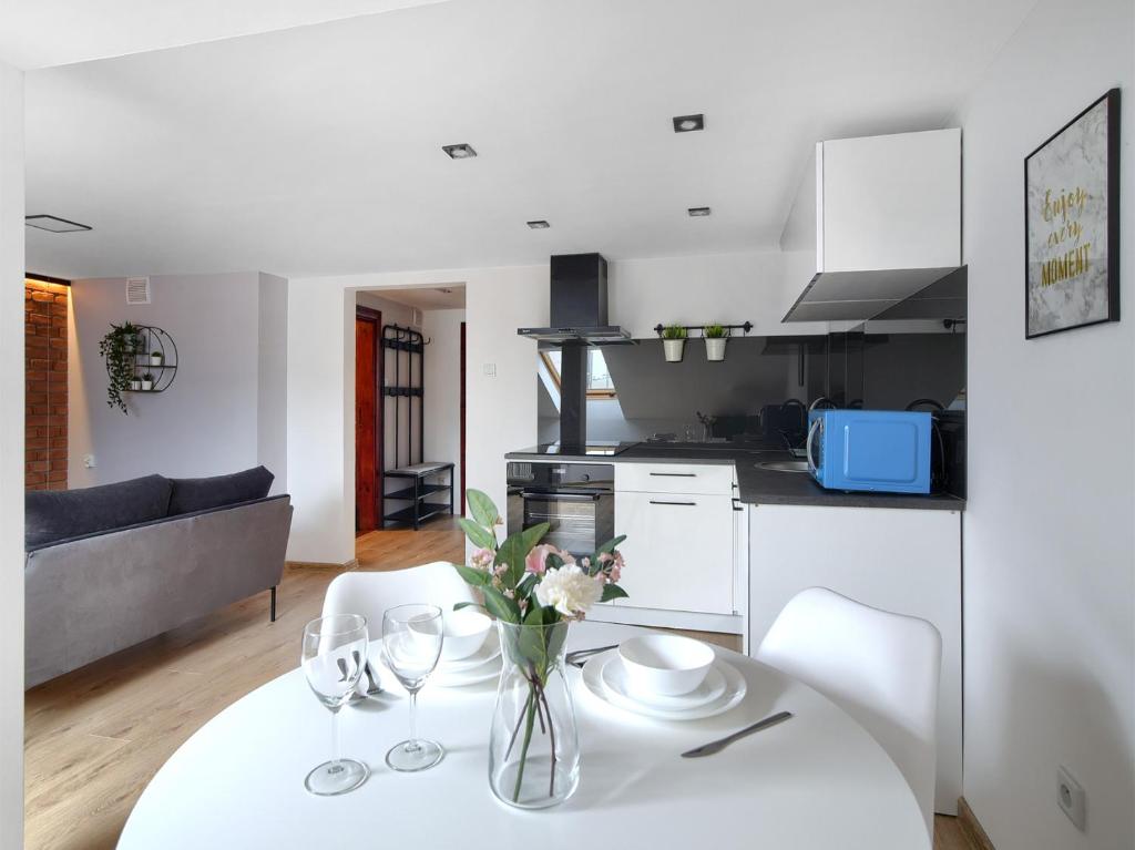 eine Küche und ein Wohnzimmer mit einem weißen Tisch und Stühlen in der Unterkunft Apartament IX Wieków CENTRUM PARKING VERY GOOD LOCATION TWO BEDROOMS 50 M2 in Kielce