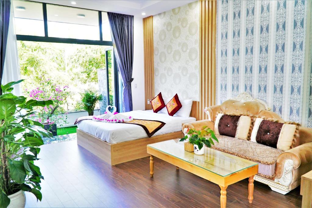 uma sala de estar com uma cama e um sofá em Minh Hung Apartment & Hotel em Da Nang