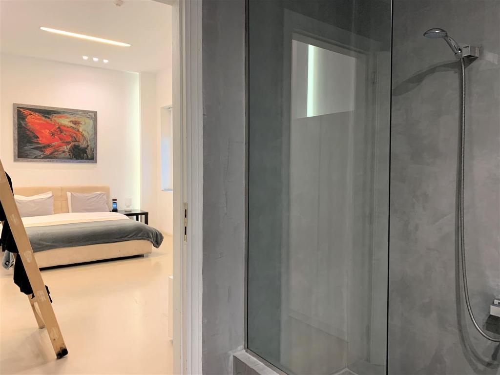 a bathroom with a shower and a bedroom with a bed at GK Athens in Athens