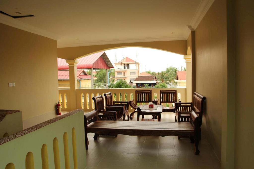 a porch with a table and chairs on a balcony at IKI IKI Guesthouse in Siem Reap