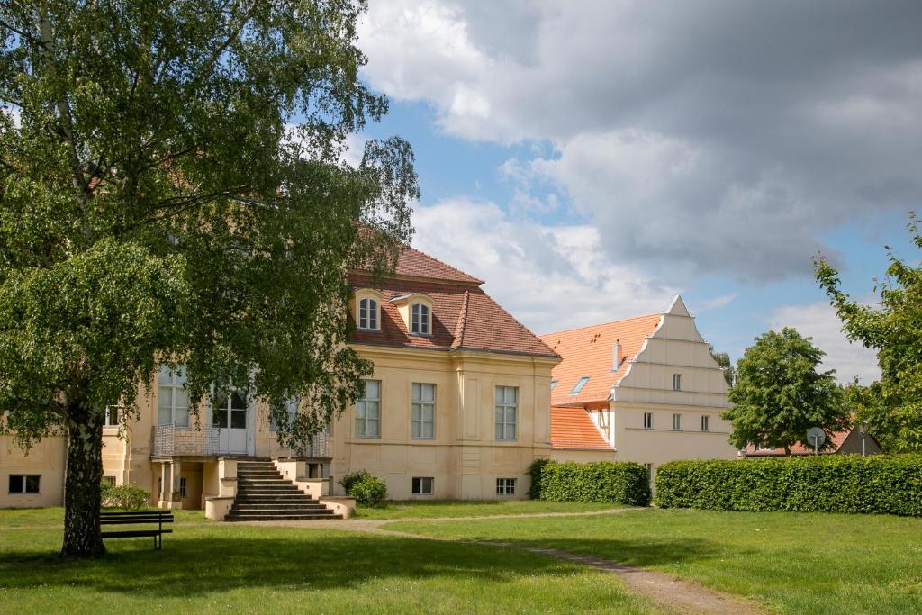 a large house with a tree in the yard at Gästehaus Reckahn der Rochow Akademie in Reckahn