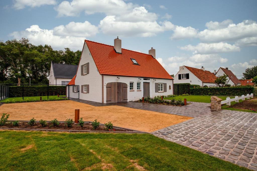 ein großes weißes Haus mit orangefarbenem Dach in der Unterkunft Niels in Nieuwpoort