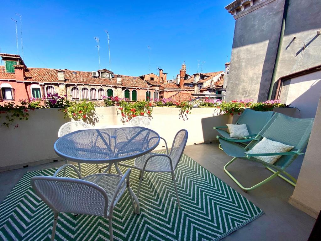 un patio con tavolo e sedie sul balcone. di Ca’ degli Oresi a Venezia