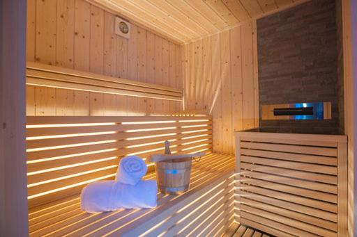una sauna con una bañera de plástico y un cubo de basura en Hotel Ristorante Milano, en Vermiglio