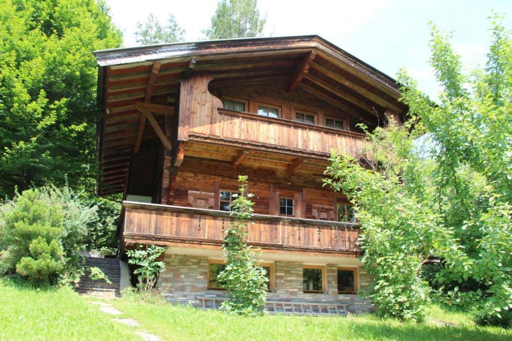 ein großes Holzhaus mit Bäumen davor in der Unterkunft Ferienhaus Schafstall in Alpbach