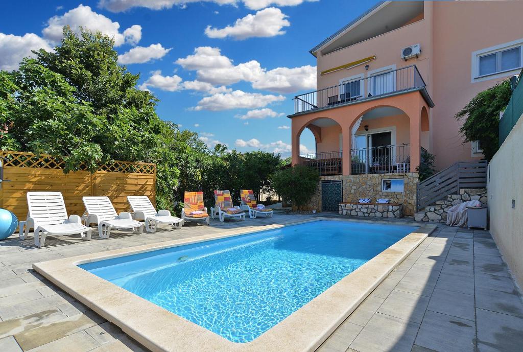 a swimming pool in front of a house at Apartments Valbandon 1008 in Fažana