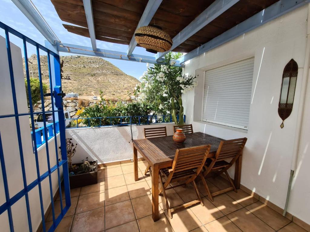 ein Esszimmer mit einem Tisch und Stühlen auf dem Balkon in der Unterkunft Las Negras CENTRO. Al lado del mar. Con dos terrazas in Las Negras
