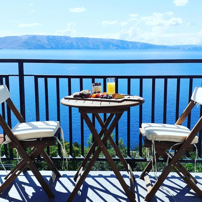 a table with a plate of food and two chairs at Room Domo in Senj