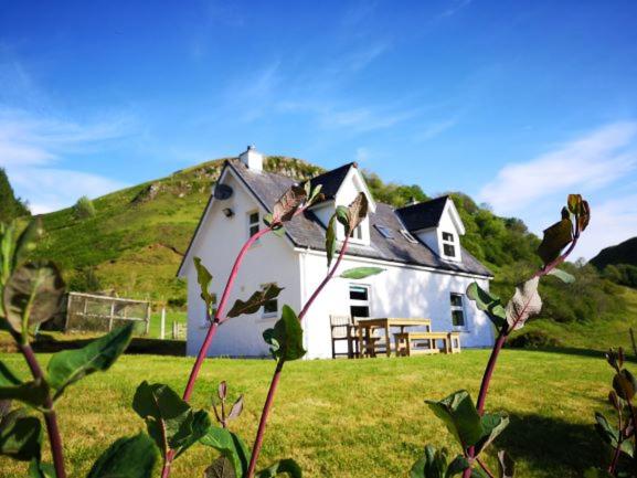 uma pequena casa branca com uma colina ao fundo em Achalic Beag em Lerags