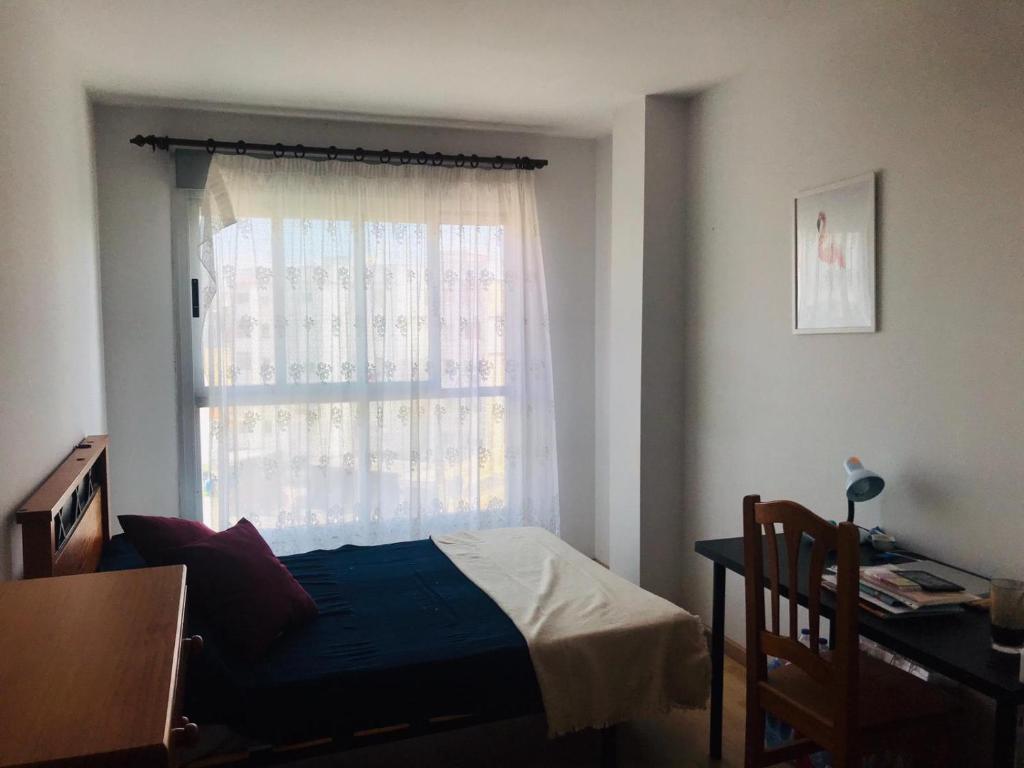 - une chambre avec un lit et une fenêtre dans l'établissement Apartamento en la playa de Gandia, à Gandía
