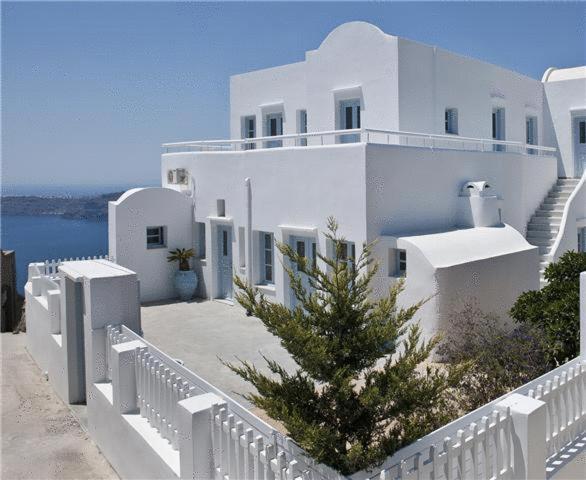 a white building with a christmas tree in front of it at Casa Florina in Imerovigli