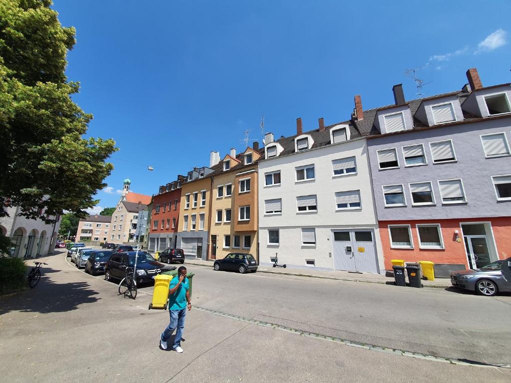 アウクスブルクにあるSteinhauser`s Ferienwohnungenの建物前の通りに立つ女