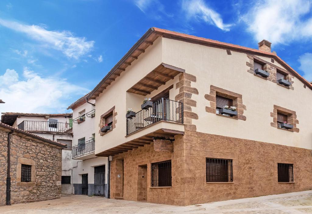 un edificio de apartamentos con balcones y un cielo azul en El Rincón de la Iglesia, en Cabezuela del Valle