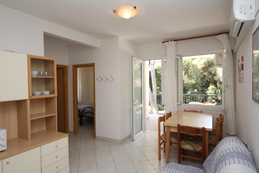 eine Küche und ein Esszimmer mit einem Tisch und Stühlen in der Unterkunft Arianna 01 in Rosolina Mare