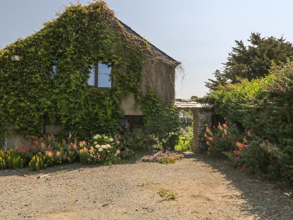 a house with a bunch of flowers in front of it at The Stable in Bude