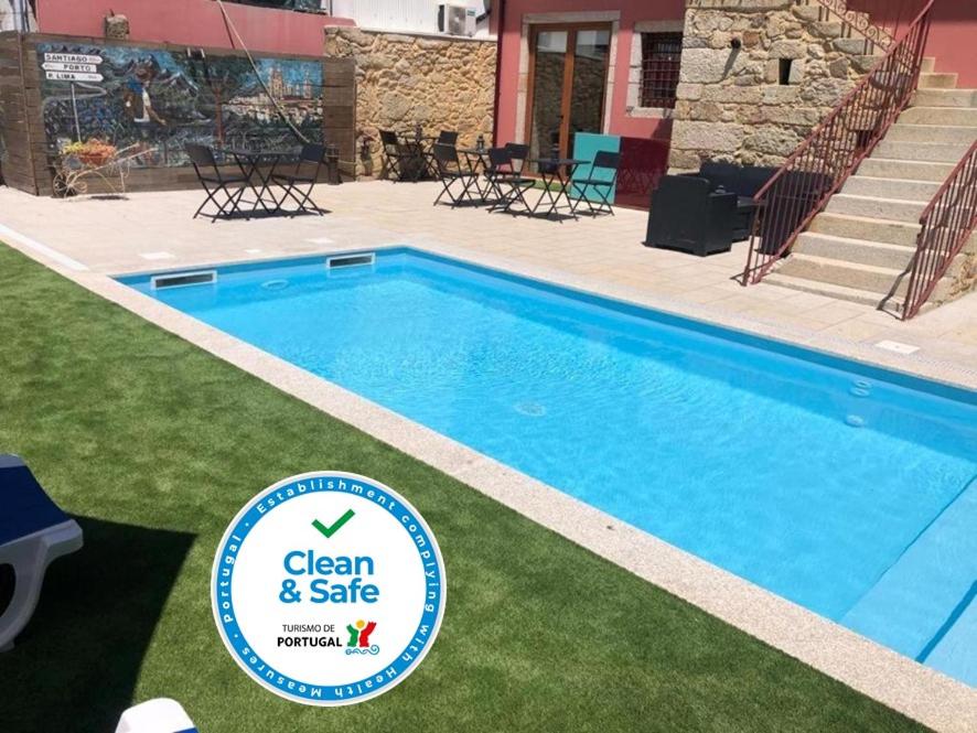 une piscine bleue avec un panneau en face de celle-ci dans l'établissement Art'Otel Barcelos, à Barcelos