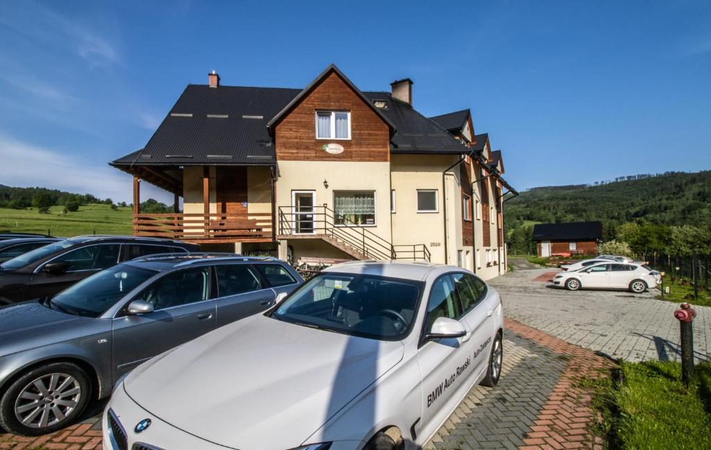 a group of cars parked in front of a house at Dom Wypoczynkowy Modrys in Zawoja