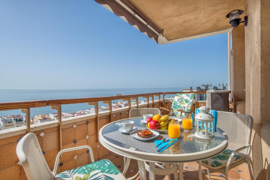 - une table avec de la nourriture sur un balcon avec vue sur l'océan dans l'établissement Aloha Amazing Sea Views at Carihuela, à Torremolinos
