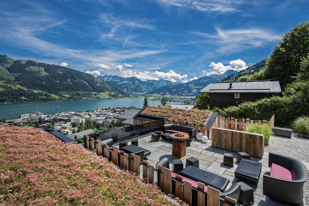 a patio with chairs and a view of a river at Senses Violett Suites - Adults Only in Zell am See