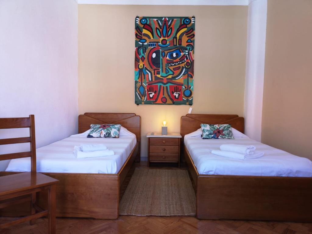 two beds in a room with a painting on the wall at Foz Surfcamp in Foz do Arelho