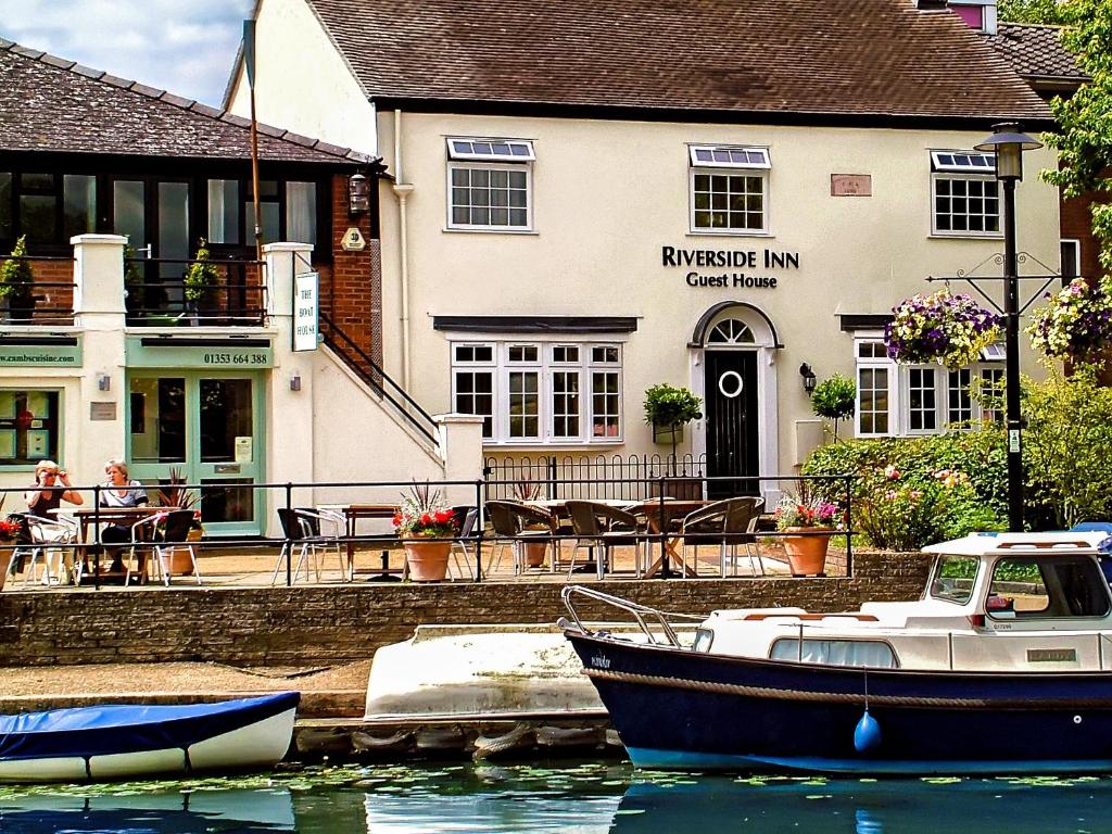 a boat in the water in front of a inn at Riverside Inn in Ely