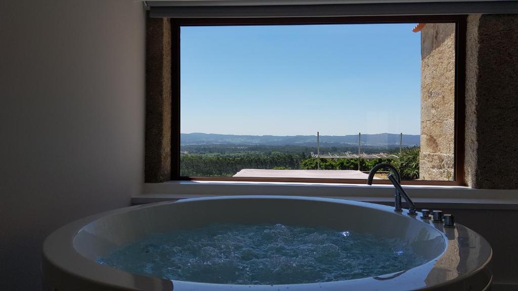 uma banheira na casa de banho com uma janela em Casas do Monte de Roques em Vila de Punhe