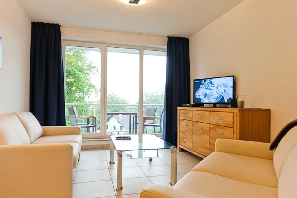 - un salon avec un canapé et une télévision dans l'établissement Haus am Südstrand Stranddistel, à Sellin