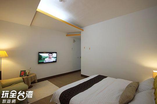 a bedroom with a bed and a tv on the wall at Amy Walker B&amp;B in Taimali