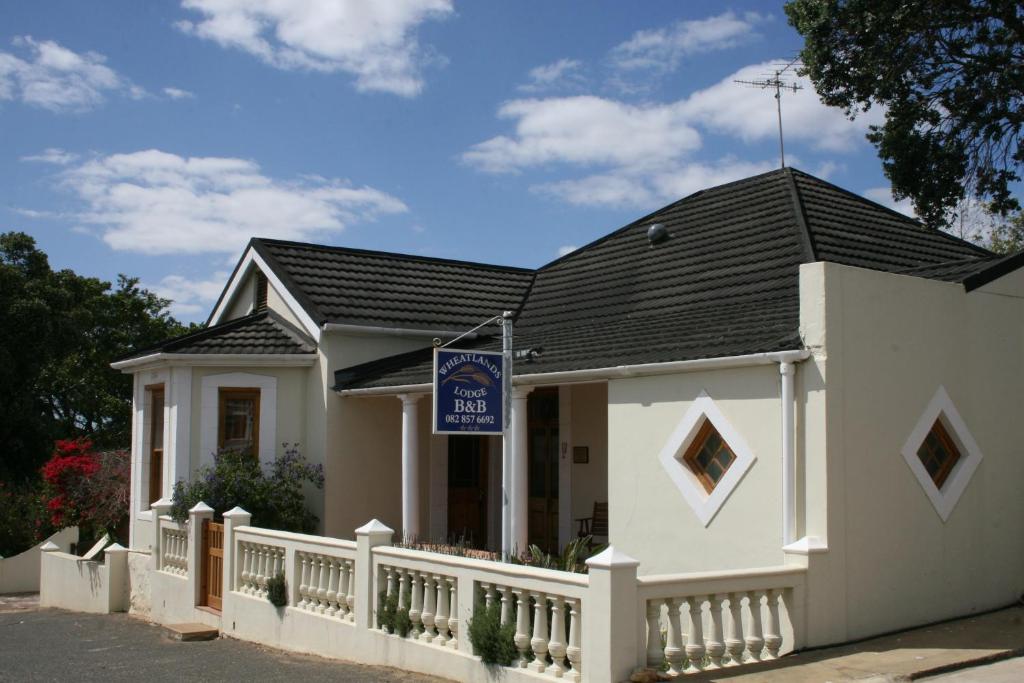 a white house with a black roof at Wheatlands Lodge in Bredasdorp