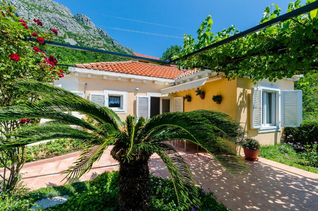 ein Haus mit einer Palme davor in der Unterkunft Holiday Home Hope in Mokošica